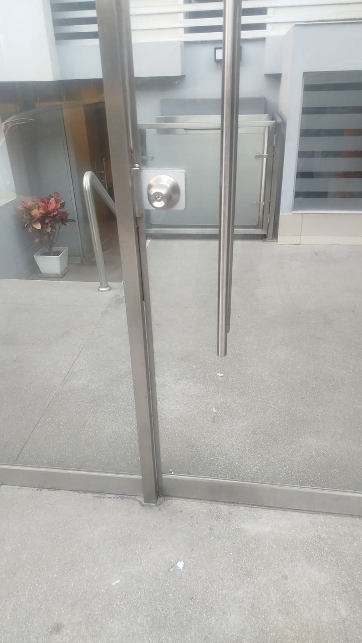 Detalle de tirador y herrajes de una puerta de vidrio templado